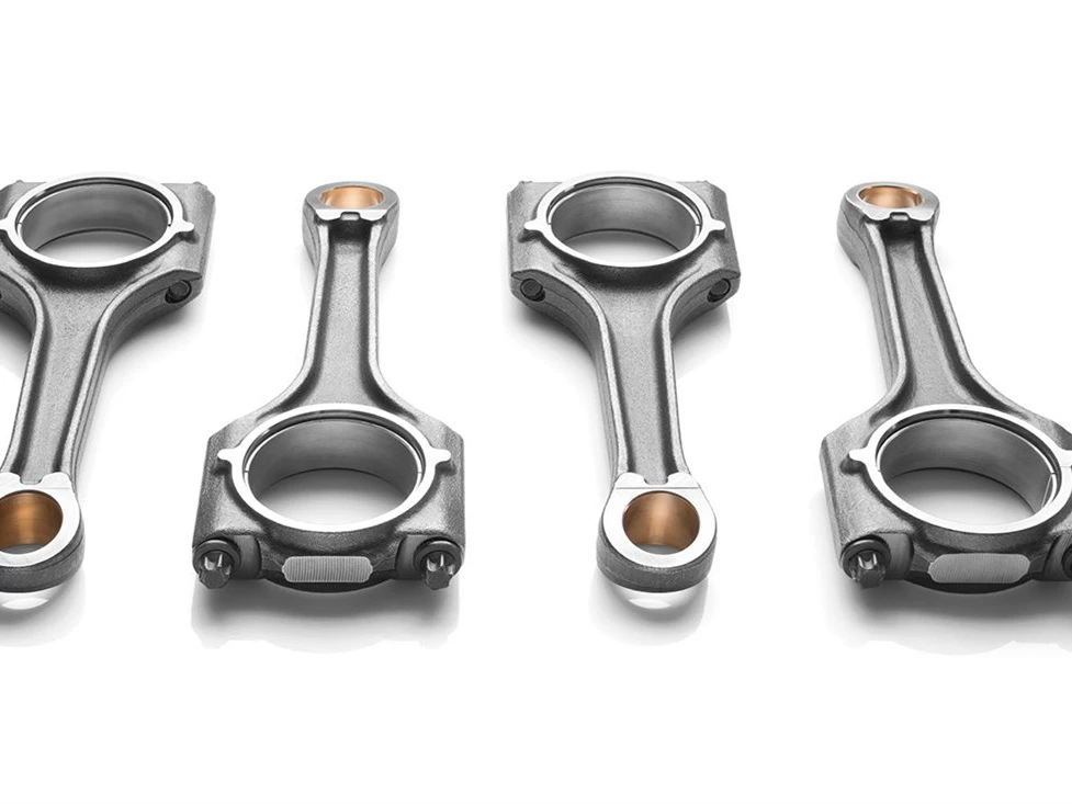 Photographs showing ductile iron in practical applications such as automotive parts eg crankshafts connecting rods pipes industrial machinery parts etc